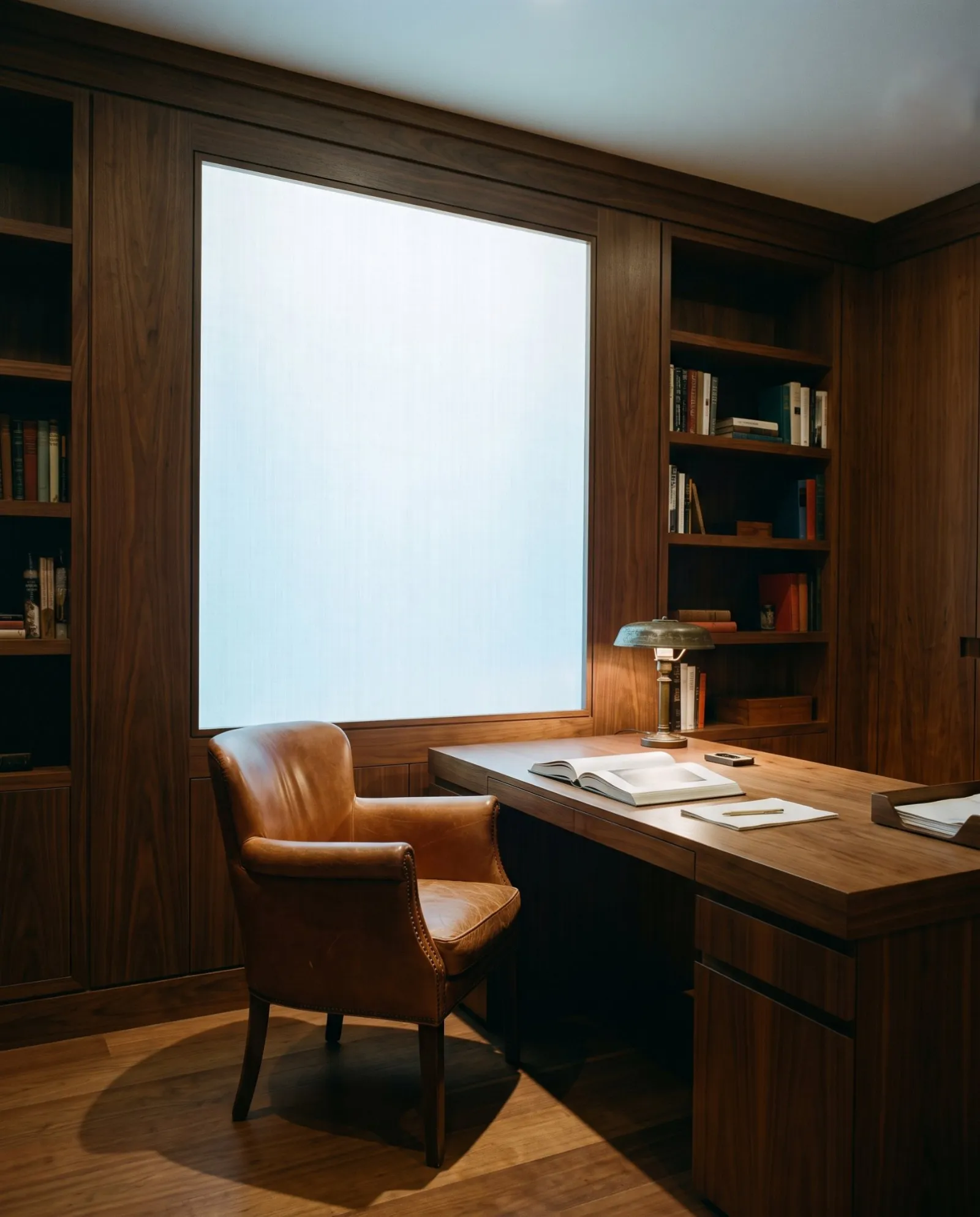 A walnut study lit by a large daylight panel set into the wall