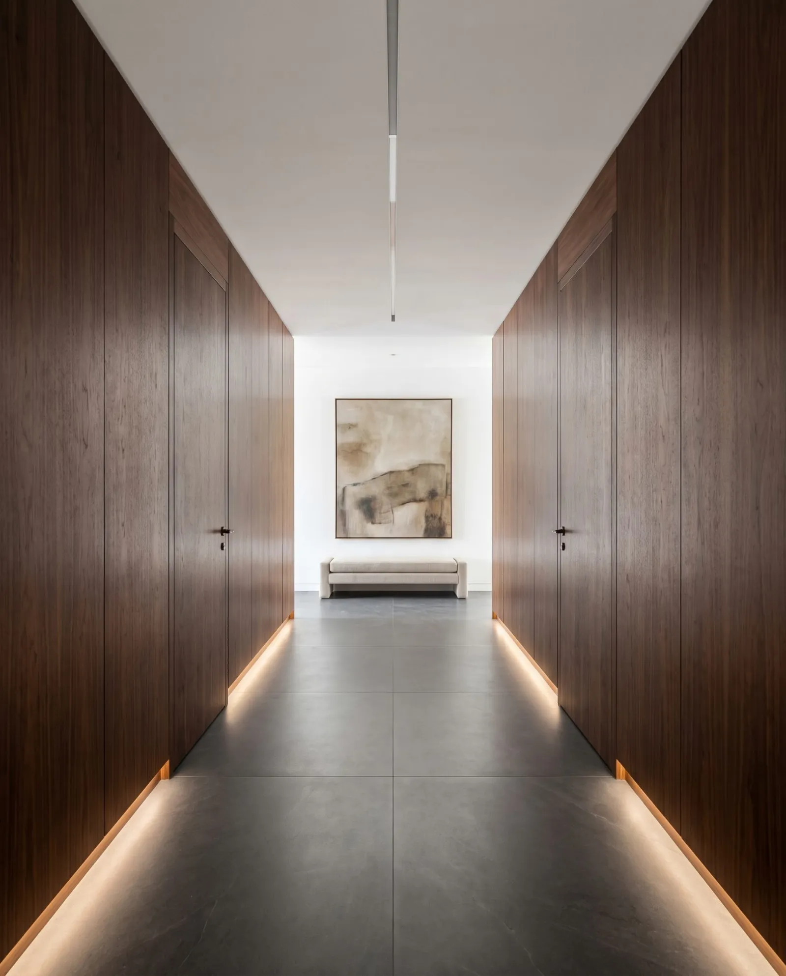A walnut-panelled corridor with flush concealed doors